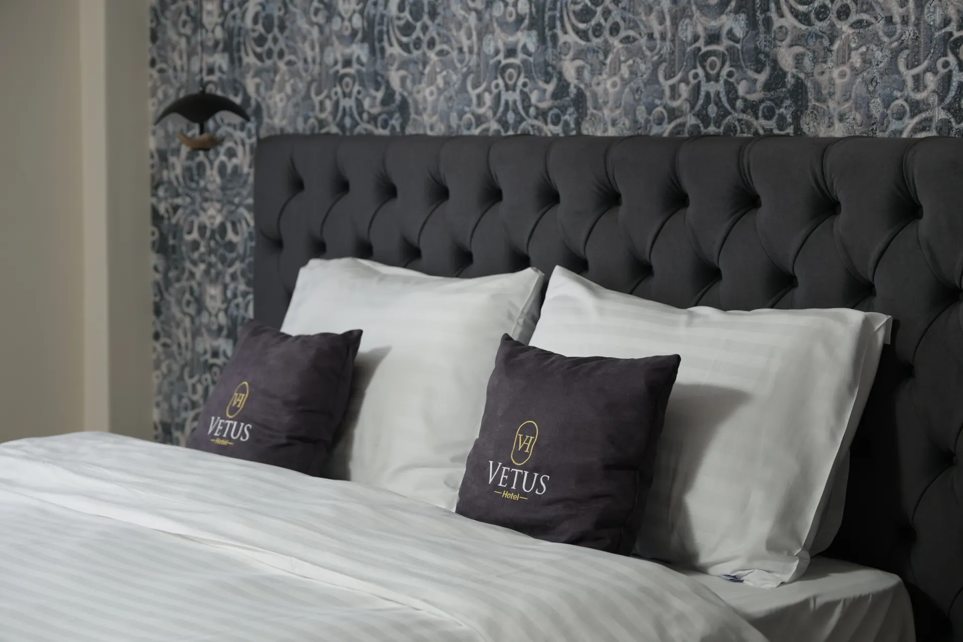 Deluxe double bed with Vetus pillows and blue damask wallpaper