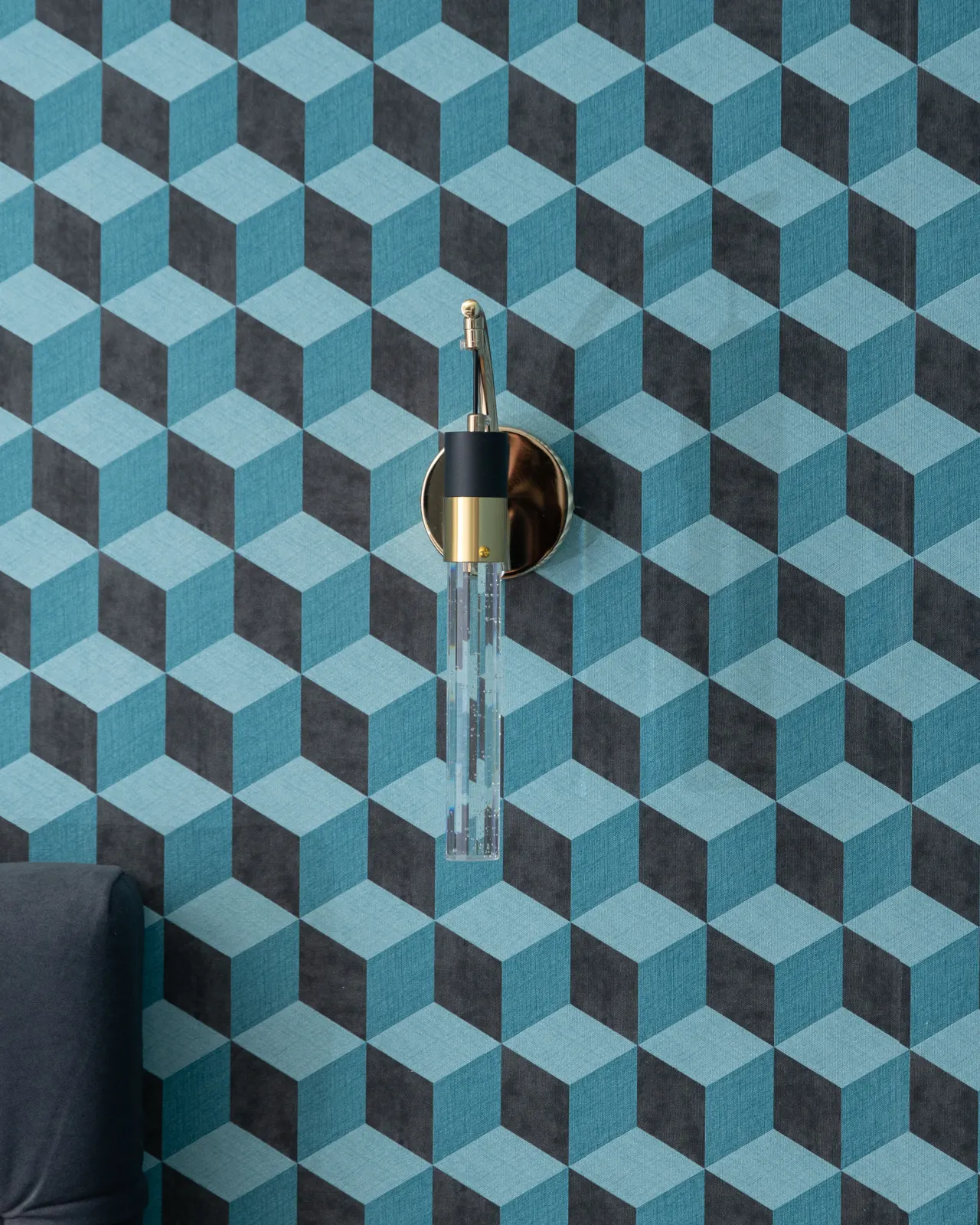 Gold wall lamp on the teal geometric wallpaper