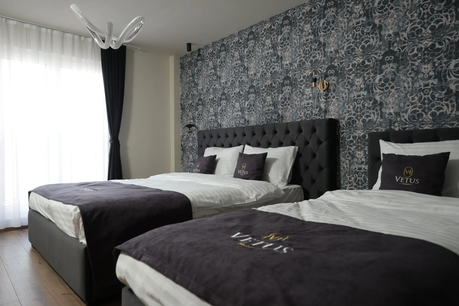 Deluxe triple room with two beds and damask wallpaper