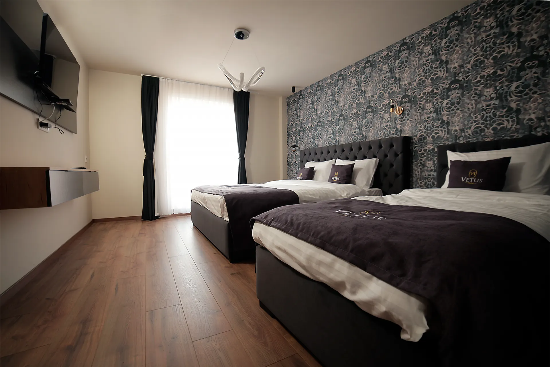 Triple room with teal wall and two beds